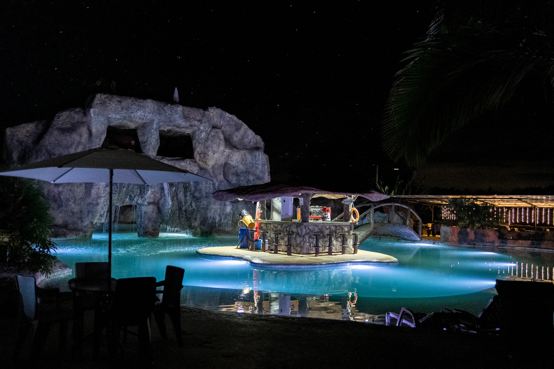 Piscina y caverna iluminadas durante la noche en el parque
